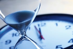 Egg timer in front of a clock