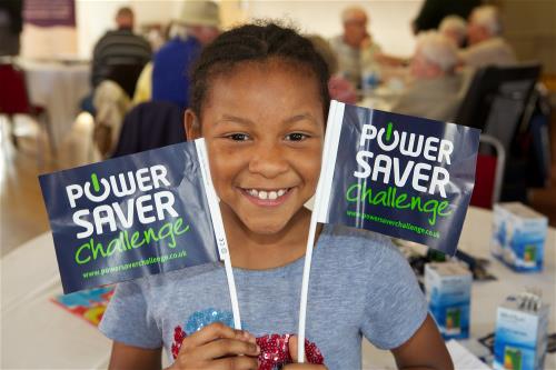 Little girl holding 'Power Save Challenge' flags